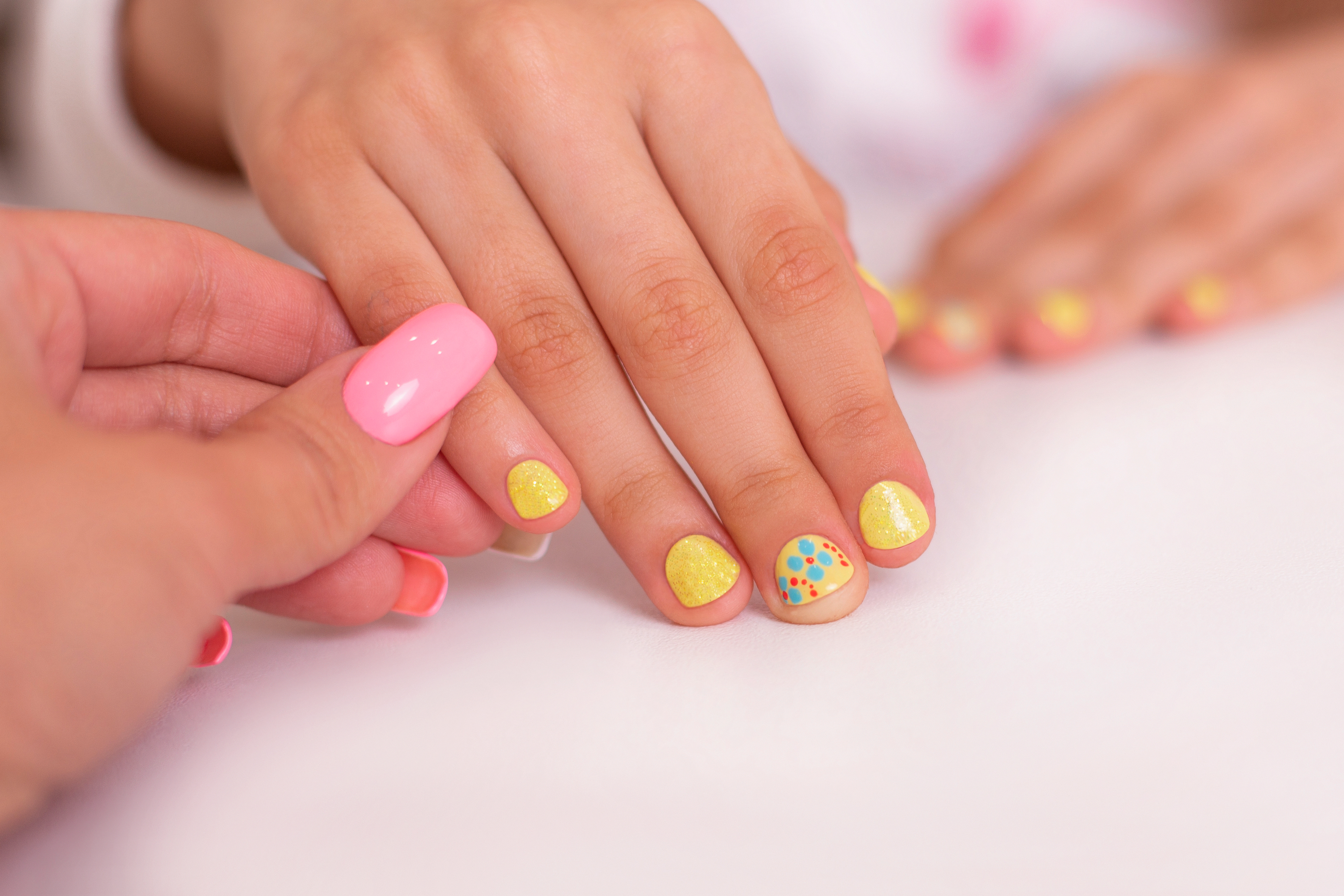 https://omgnailsspa.us/wp-content/uploads/2022/09/little-girl-hands-with-yellow-manicure-nails-flower-design.jpg